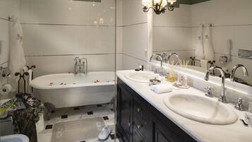 Une salle de bain moderne avec un meuble-lavabo à deux vasques, une baignoire et un grand miroir.