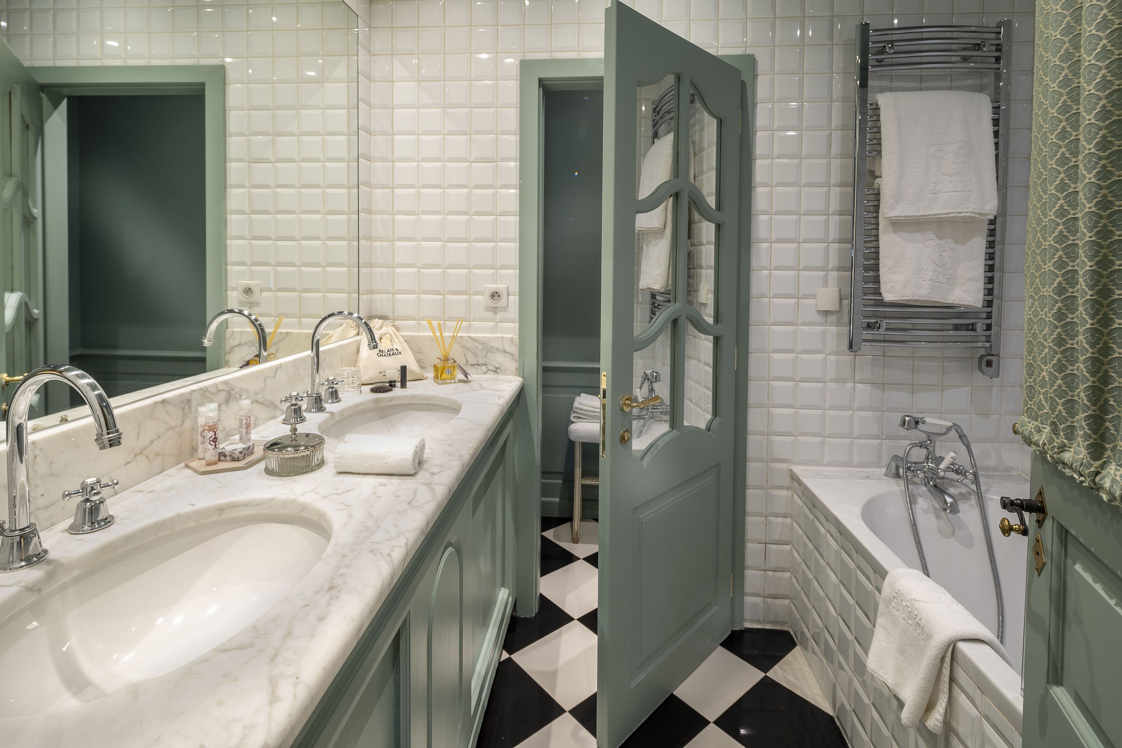 Un baño con lavamanos doble, bañera y ducha.