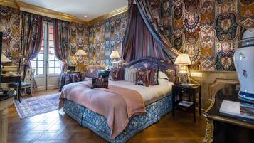 Une chambre spacieuse avec un grand lit, des rideaux décoratifs et un papier peint à motifs.
