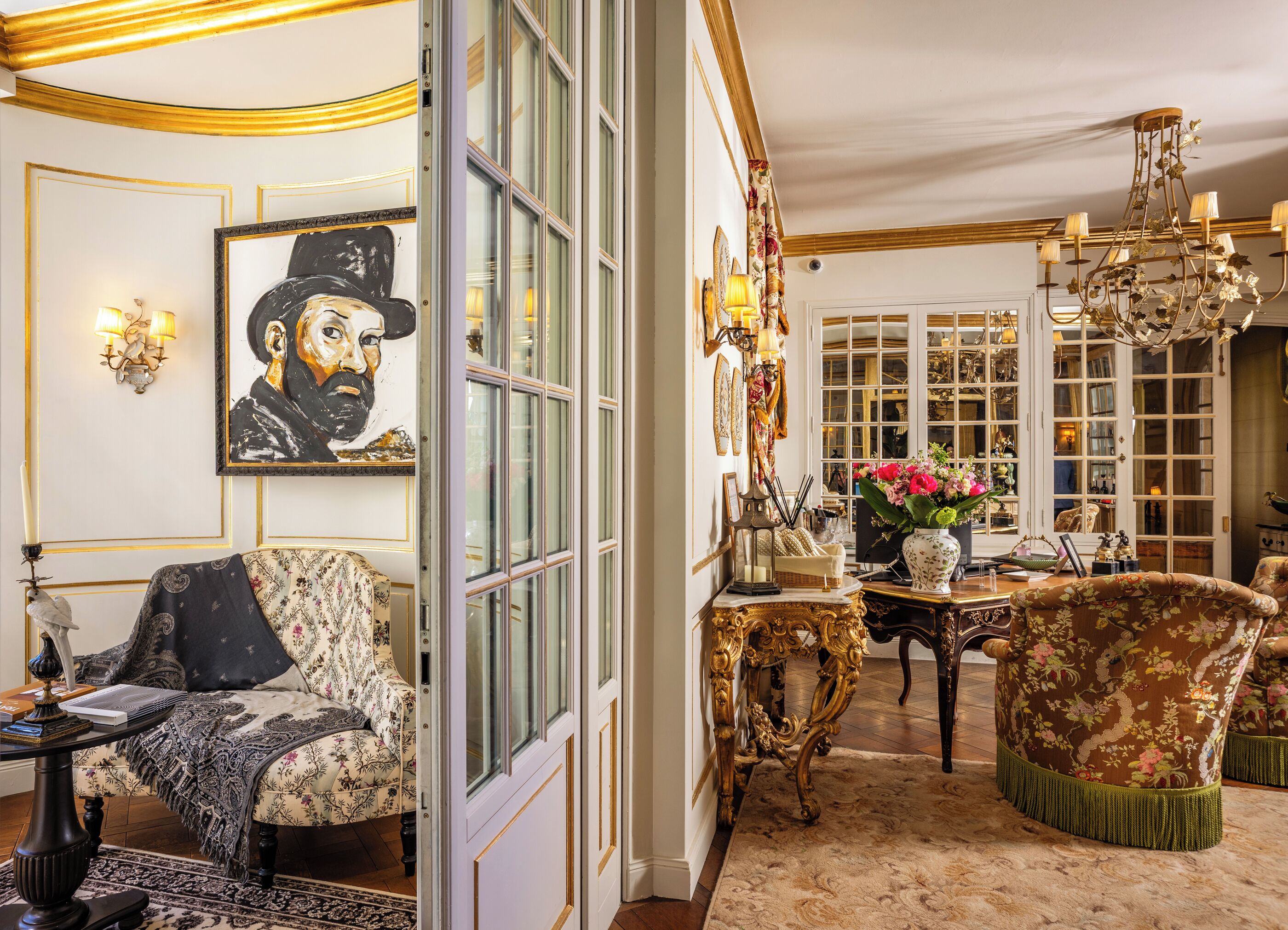 A luxurious room with ornate furniture, a large painting, and a chandelier.
