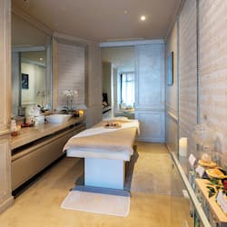 Relax in a stylish bathroom with a central bench, large mirror, and sink with countertop.