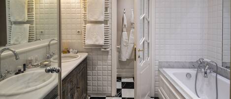 Une salle de bain avec deux éviers, une baignoire et une douche.
