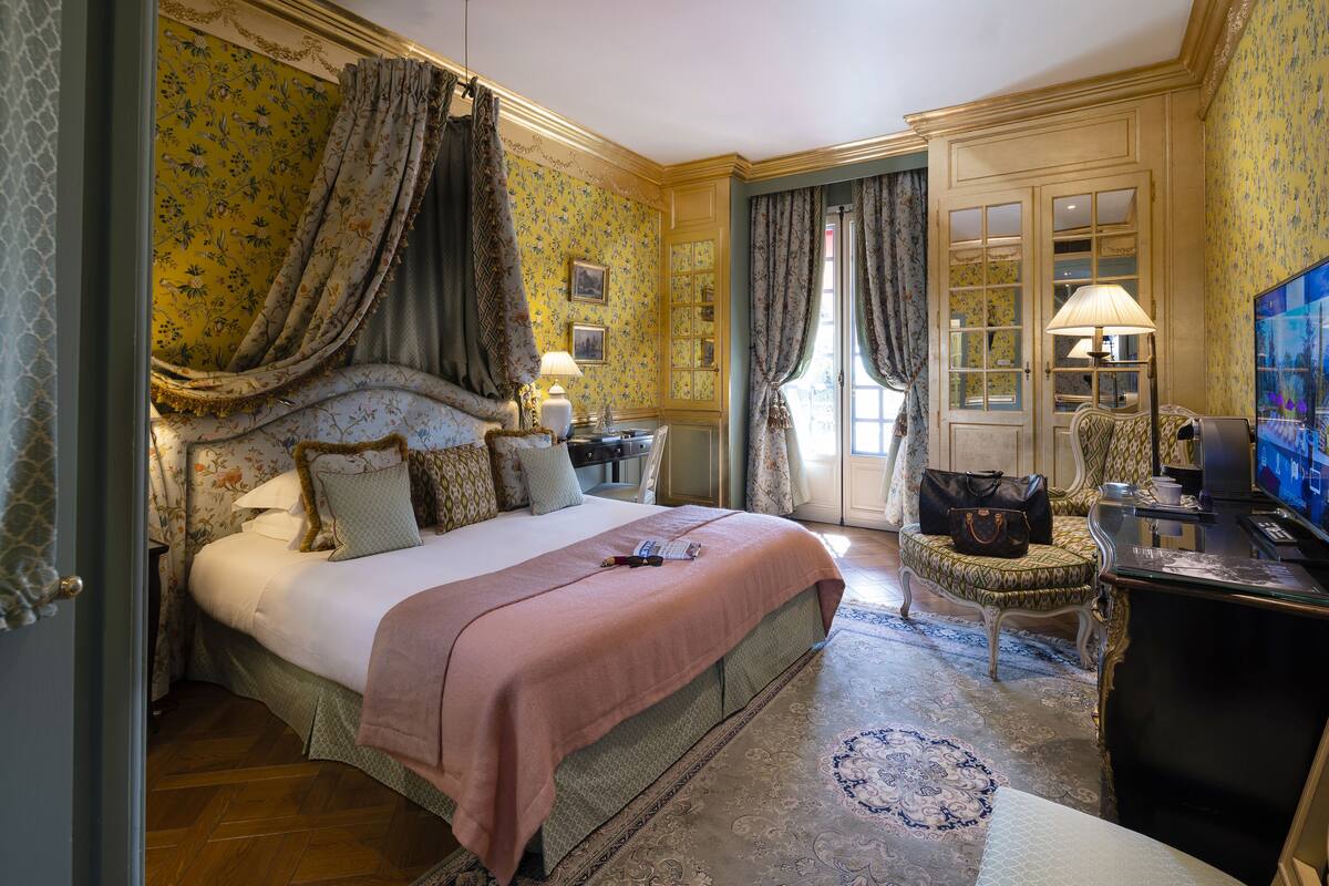 Une chambre spacieuse avec un grand lit, un bureau et une télévision.
