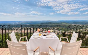 Une table dressée pour deux personnes, offrant une vue imprenable sur un paysage montagneux.
