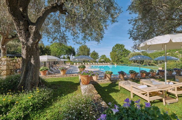 Een buitenzwembad, zwembadcabana's (toeslag) en parasols bij het zwembad