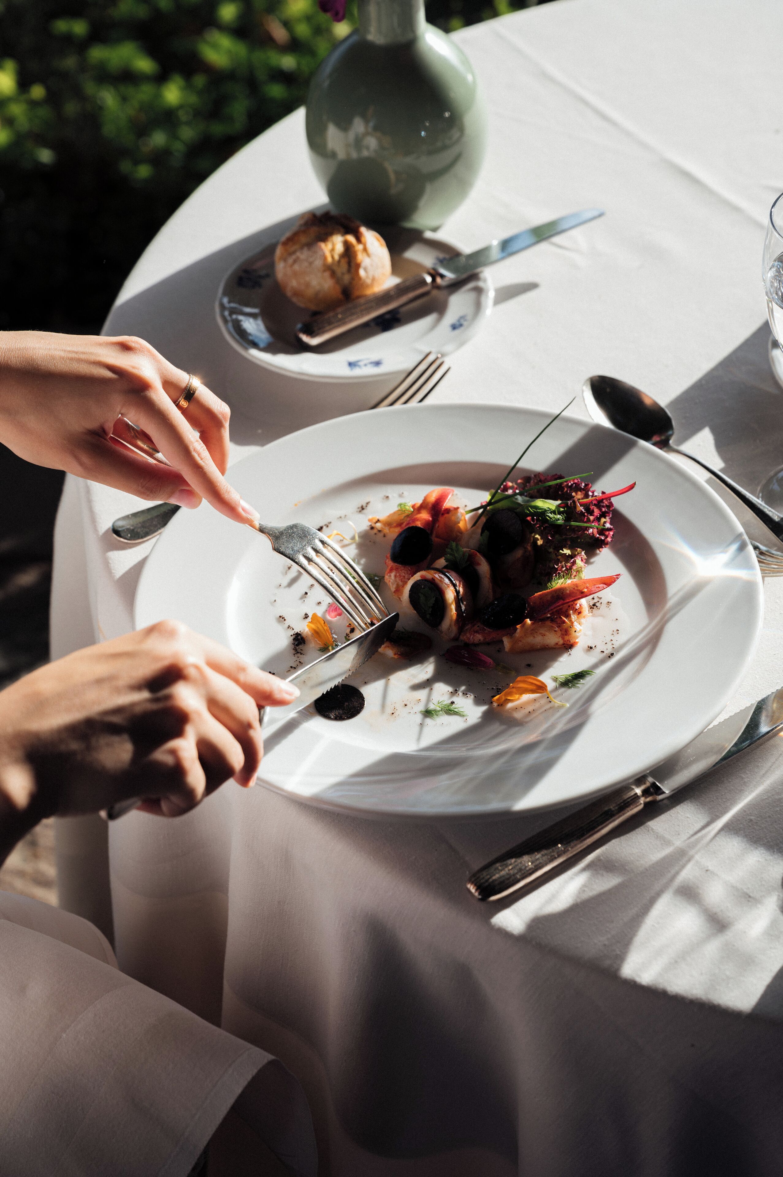 A dining table with a plate of food, utensils, and a glass of water.
