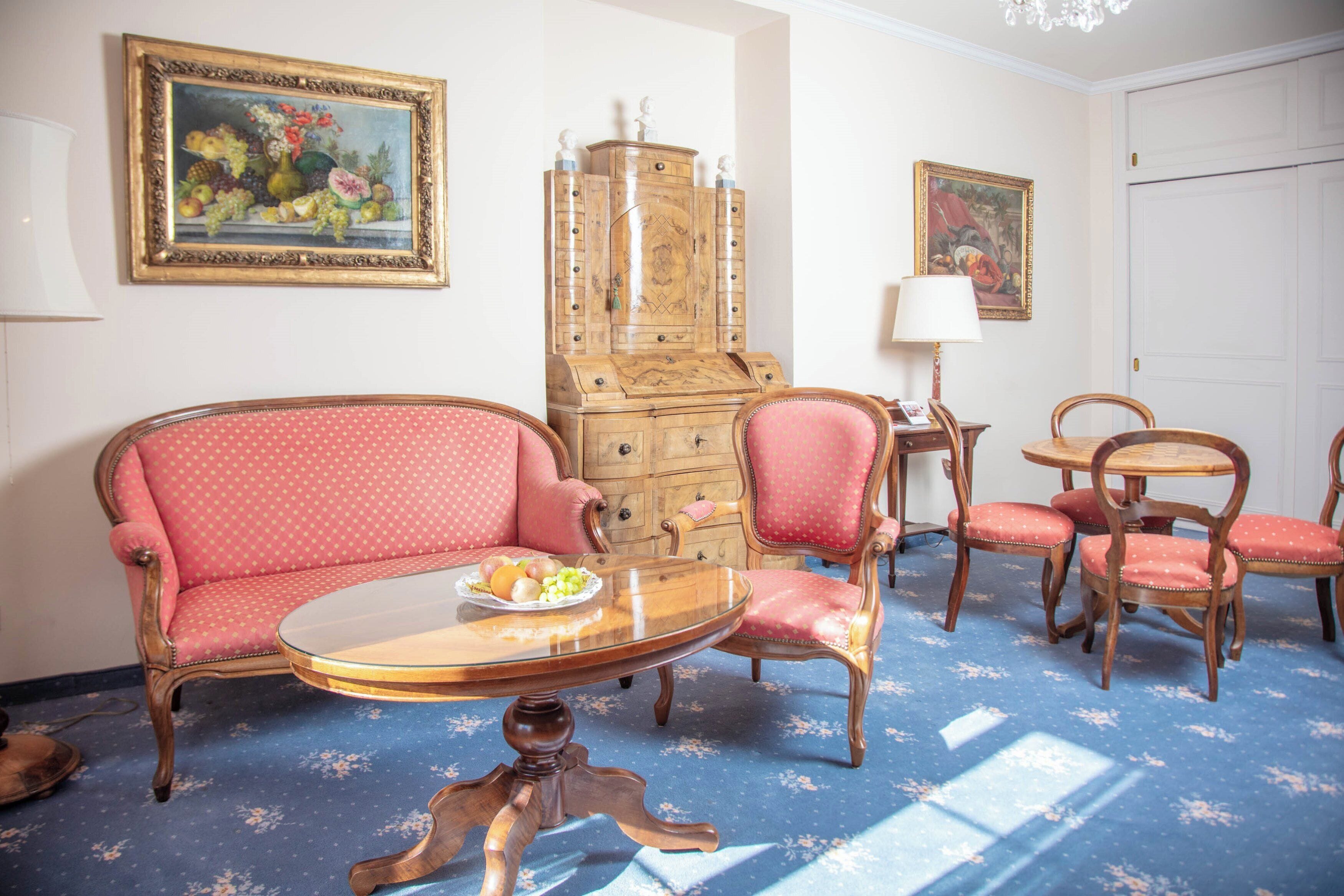 Una habitación con sofá, sillas, una mesa y un armario.