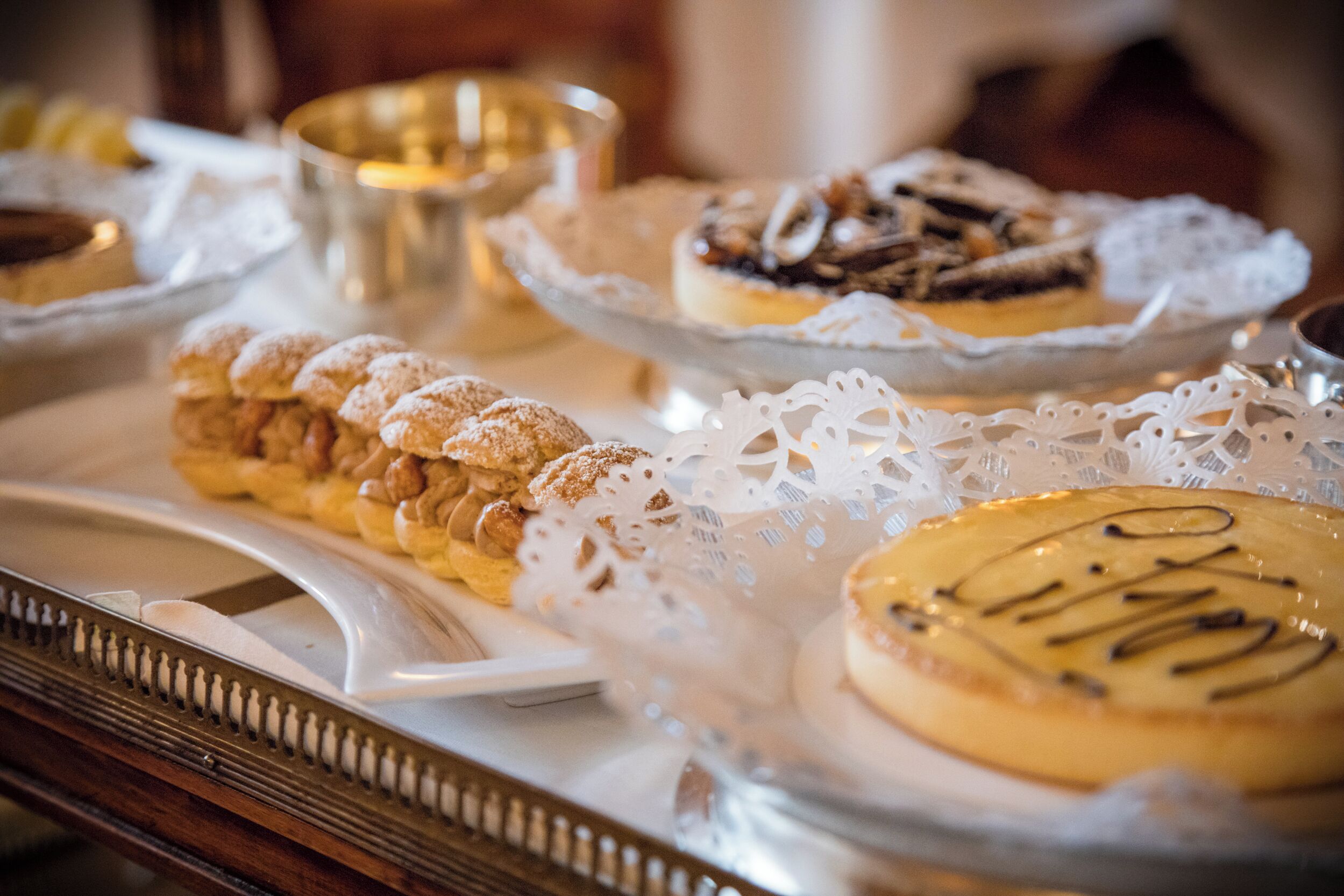 A variety of desserts on a tray, including pastries and a cake with 'PIZZA' written on it.