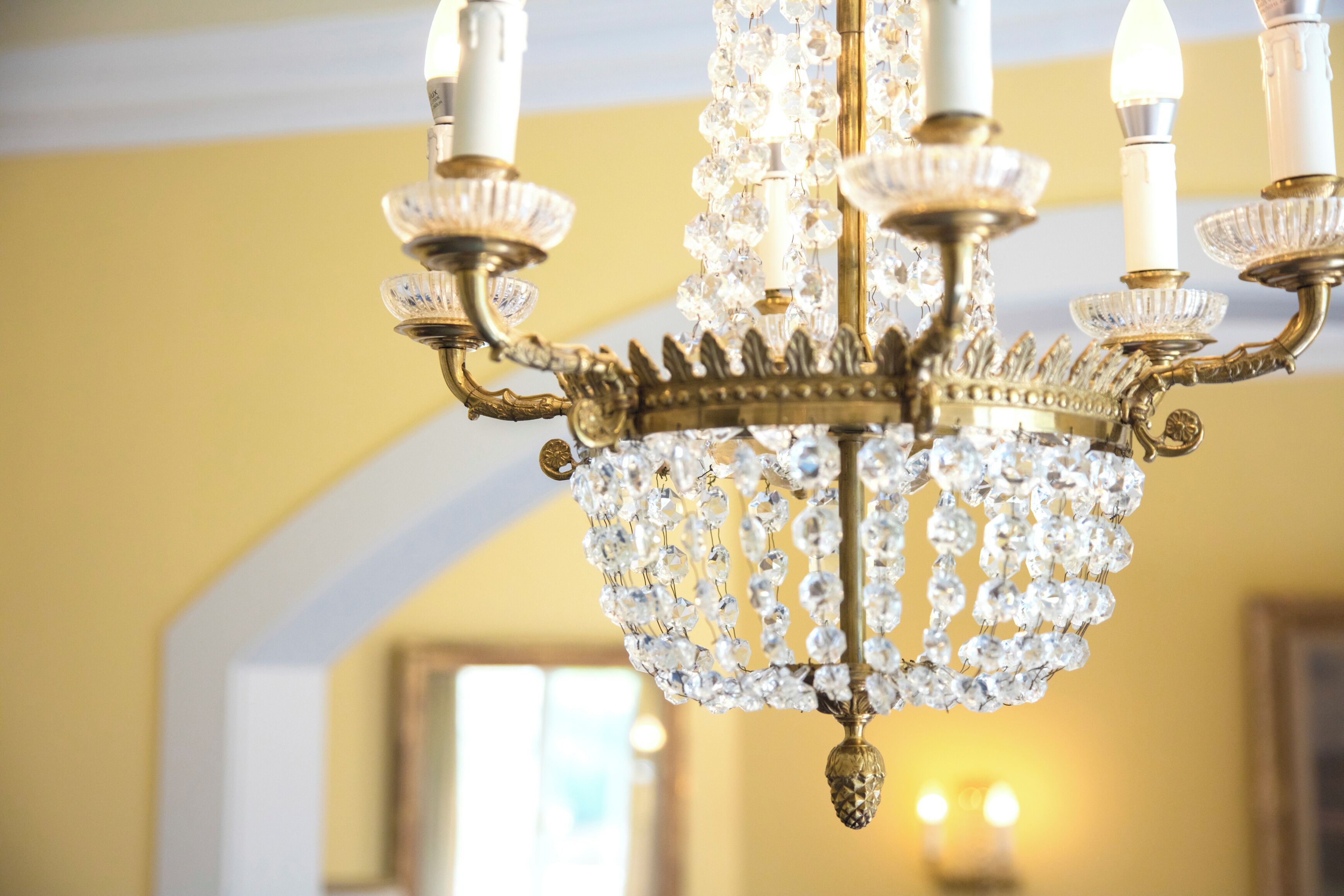 A chandelier with multiple crystal elements and a gold-colored base.