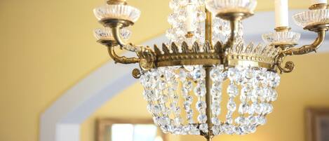 A chandelier with multiple crystal elements and a gold-colored base.