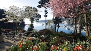 A waterfront garden with a gazebo, chairs, and blooming flowers. - Hastings House Country House Hotel (Salt Spring Island)