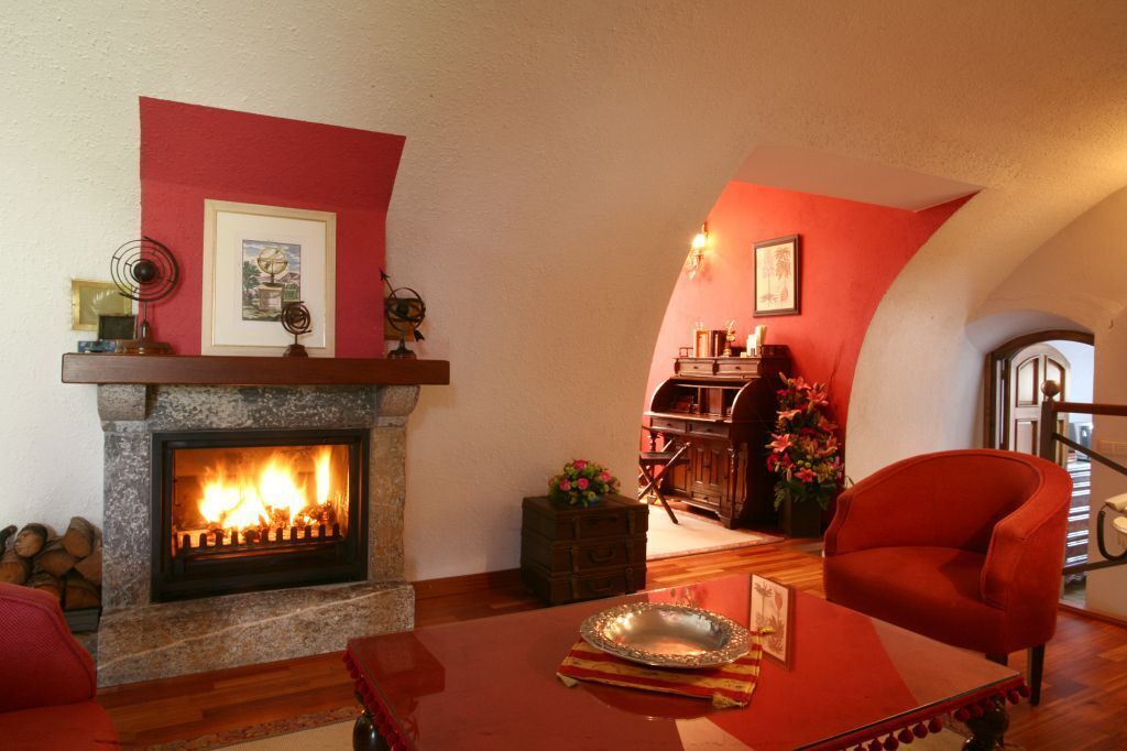 Ein gemütliches Wohnzimmer mit Kamin, Holzmöbeln und einer roten Akzentwand.