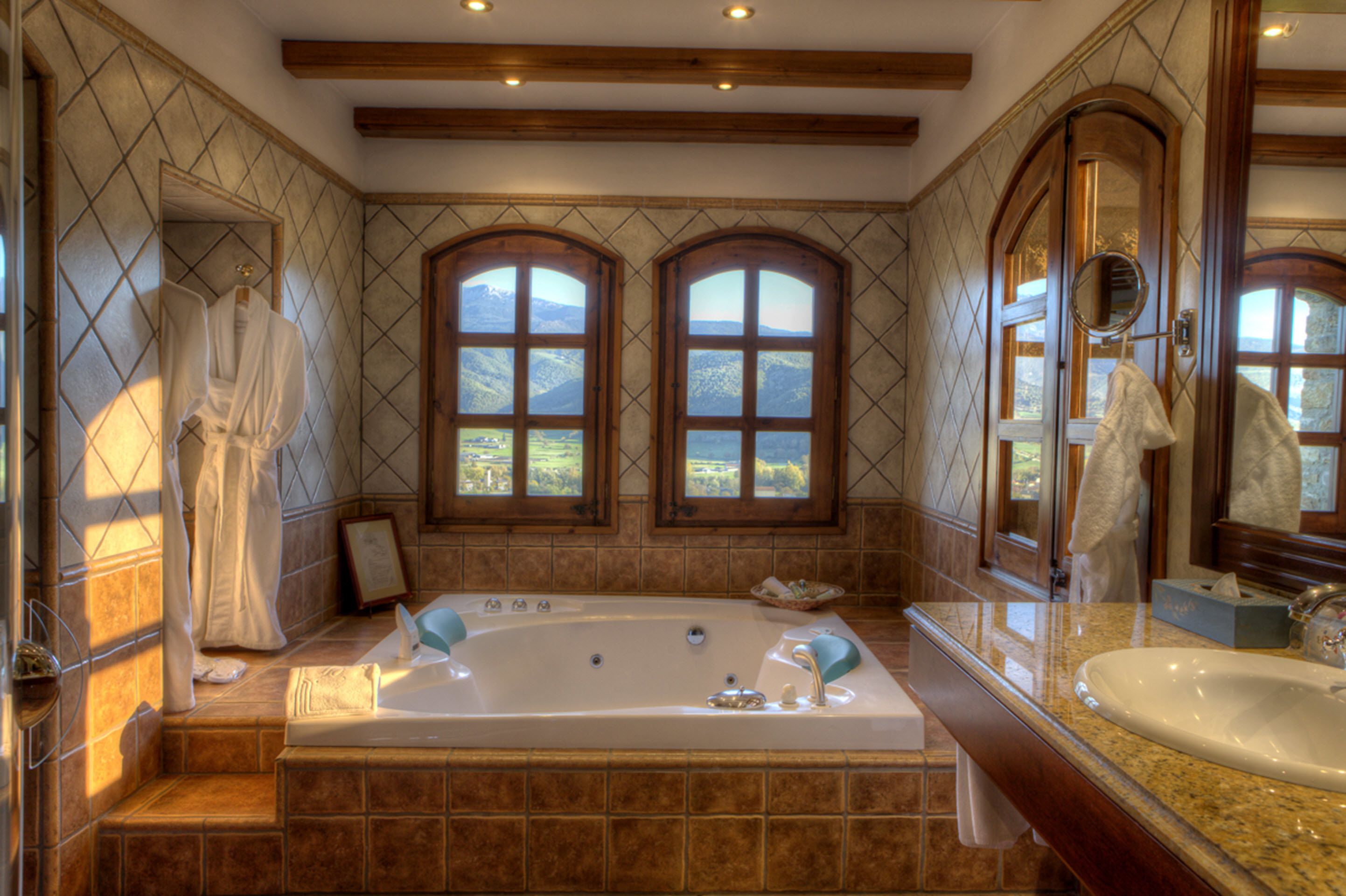 Un baño con una bañera grande, dos ventanas de arco y un techo de madera.