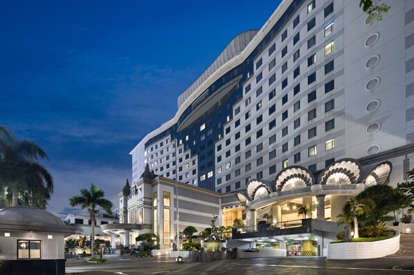 A large hotel with multiple floors, a central courtyard, and palm trees. - Golden Boutique Hotel Kemayoran (Jakarta)