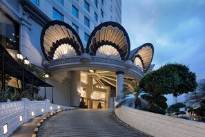 A grand hotel entrance with a distinctive circular design, a covered walkway, and a well-lit facade. - Golden Boutique Hotel Kemayoran (Jakarta)