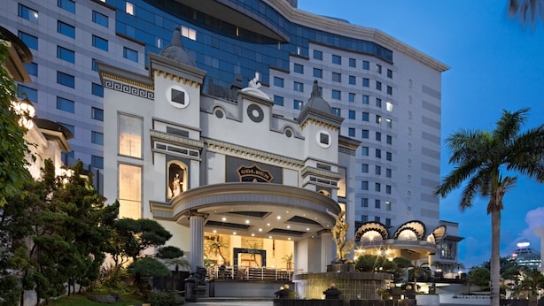 A large hotel with a grand entrance, multiple floors, and a well-lit facade.