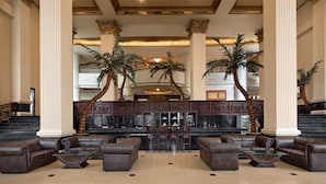 A lobby with high ceilings, large columns, and a reception desk.
