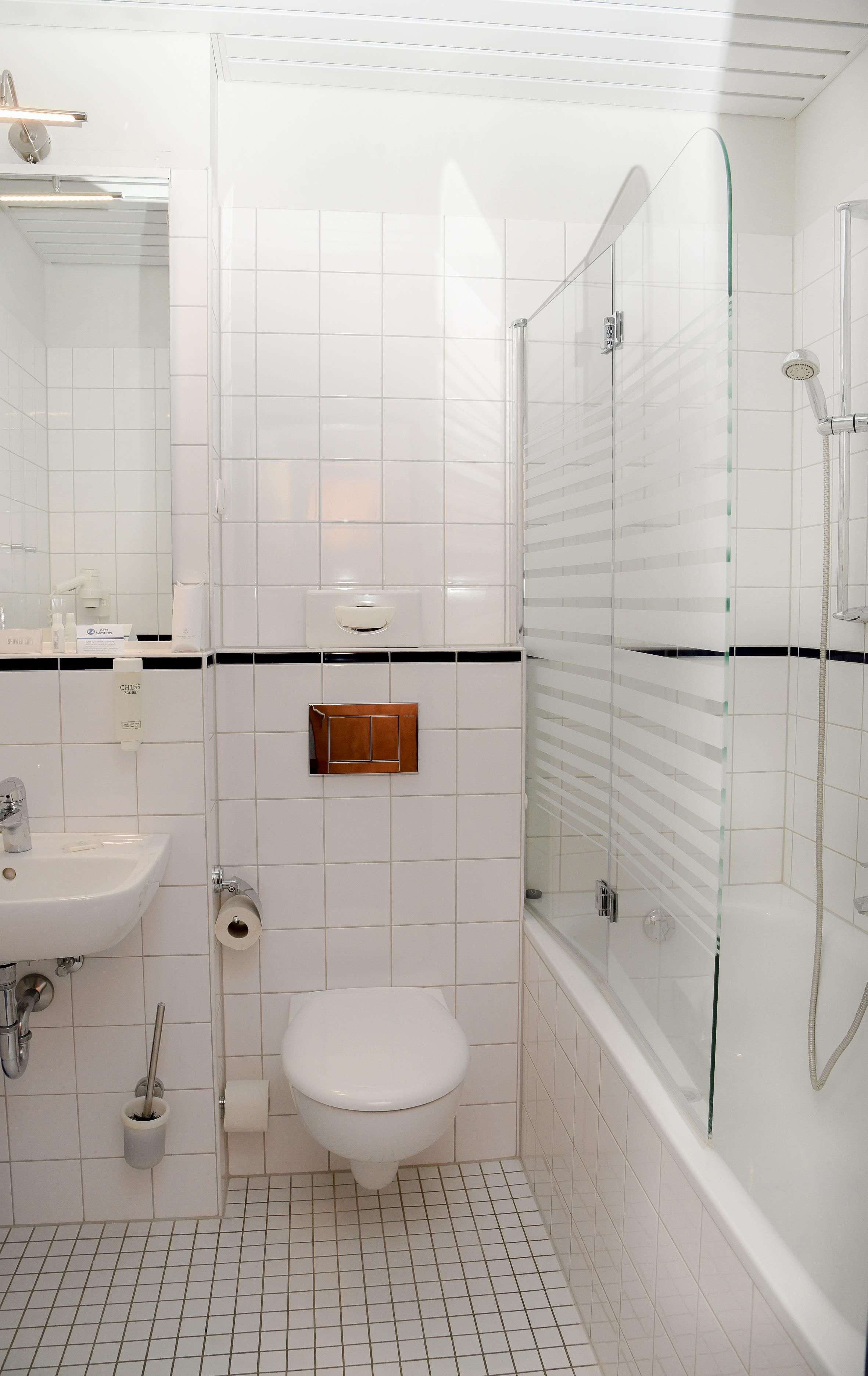 Ein modernes Badezimmer mit Toilette, Waschbecken und einer Duschkabine.
