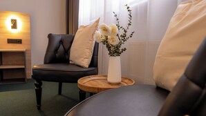 Et moderne værelse med en lædersofa, et træsidebord og en vase med blomster.