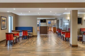 A hotel lobby with a reception desk, seating area, and a television screen. - Best Western Rochelle Inn & Suites near DeKalb (Rochelle)