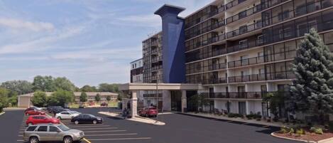 A multi-story hotel with a parking lot in front.