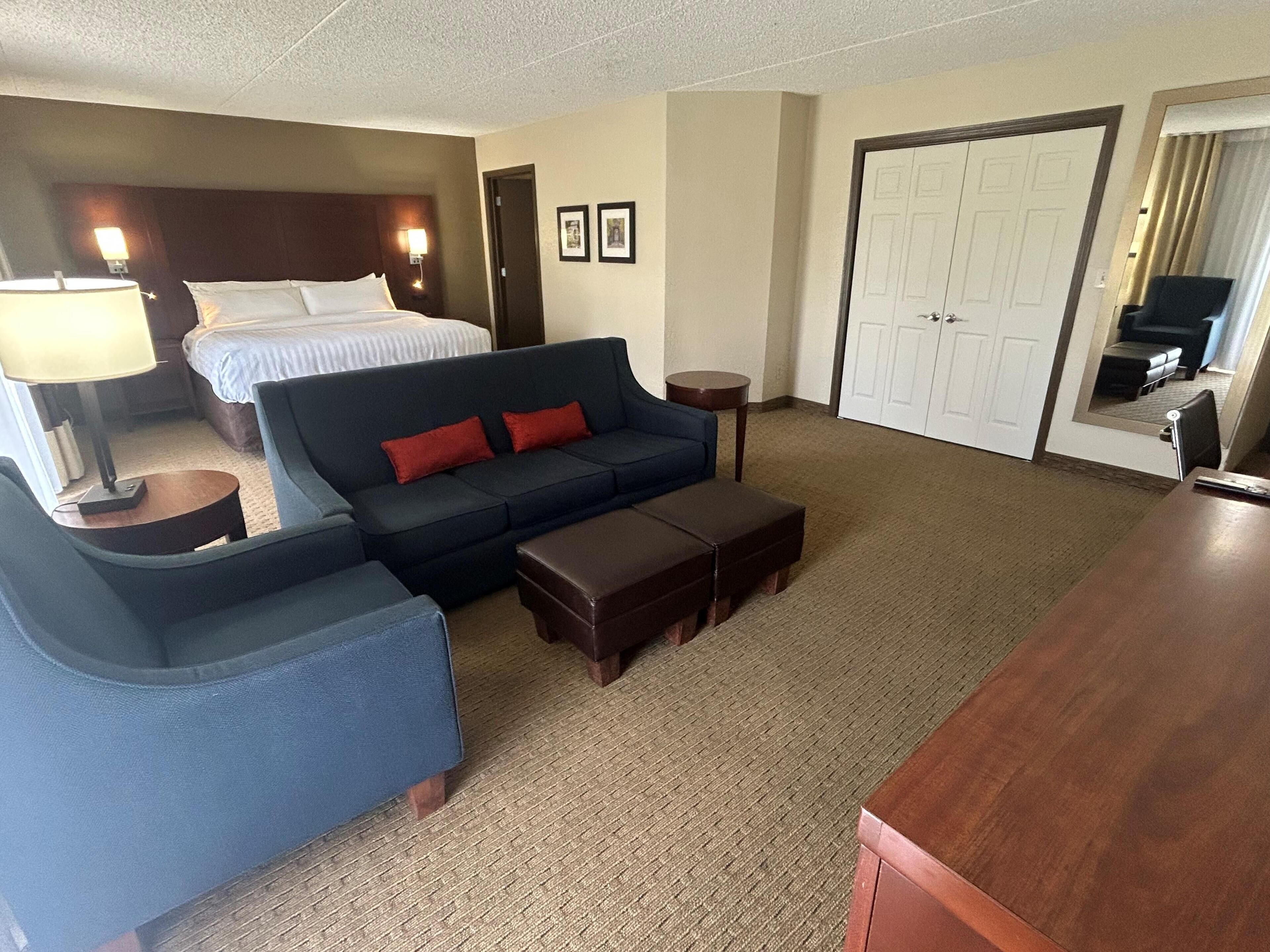 Een hotelkamer met een bed, een sofa, een bureau en een stoel.