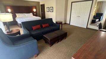 Een hotelkamer met een bed, een sofa, een bureau en een stoel.