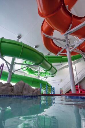 Une structure de toboggan aquatique comprenant plusieurs toboggans, une piscine et un escalier.