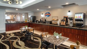 A modern kitchen with a breakfast bar, granite countertops, and a coffee machine.