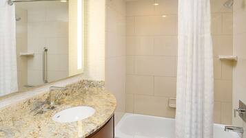 A bathroom with a marble sink, a bathtub, and a shower.