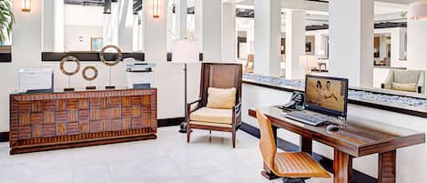 A reception area with a wooden reception desk, a computer, and a comfortable chair.