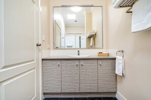 Un bagno con un ampio specchio, un lavandino e un porta asciugamani.