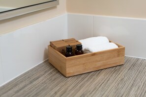 Una scatola di legno con bottiglie e un asciugamano bianco su un pavimento in legno.
