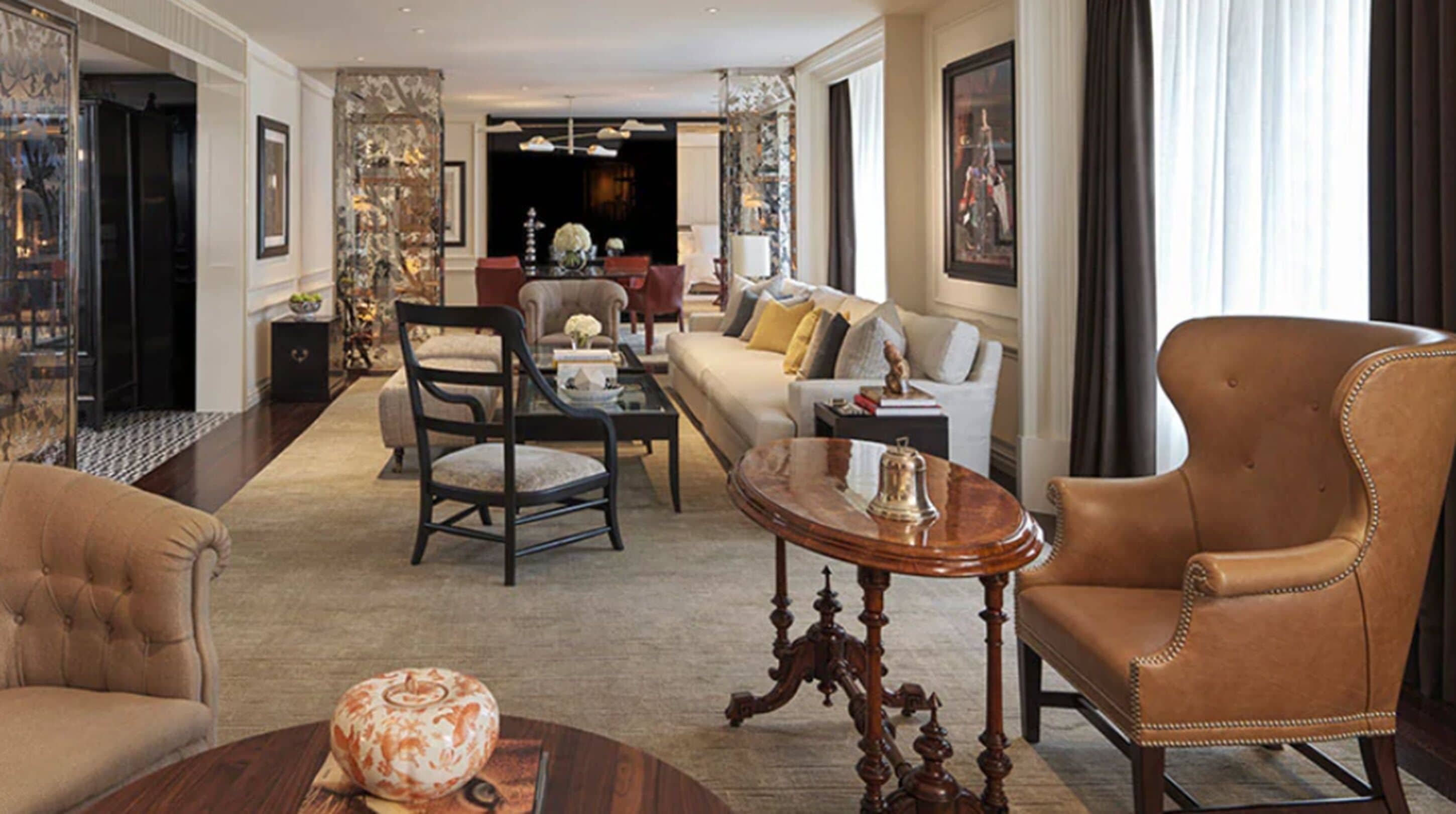 Un salon spacieux comprenant un canapé, des fauteuils, une table basse et une table décorative agrémentée d’un vase.