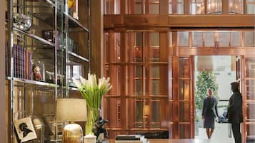 Eine geräumige Bibliothek mit Bücherregalen, einem Holztisch und einem großen Fenster.