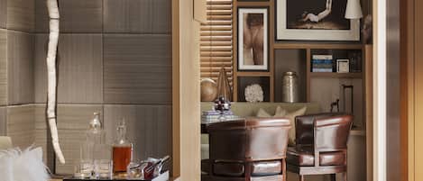 Una sala de estar moderna con un sofá, una mesa de centro con bebidas, y un comedor con sillas y una mesa.