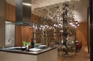 Uma cozinha moderna com ilha de vidro, eletrodomésticos de aço inoxidável e um painel de parede decorativo com flores.