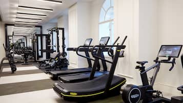 A gym with treadmills, elliptical machines, and weightlifting equipment.