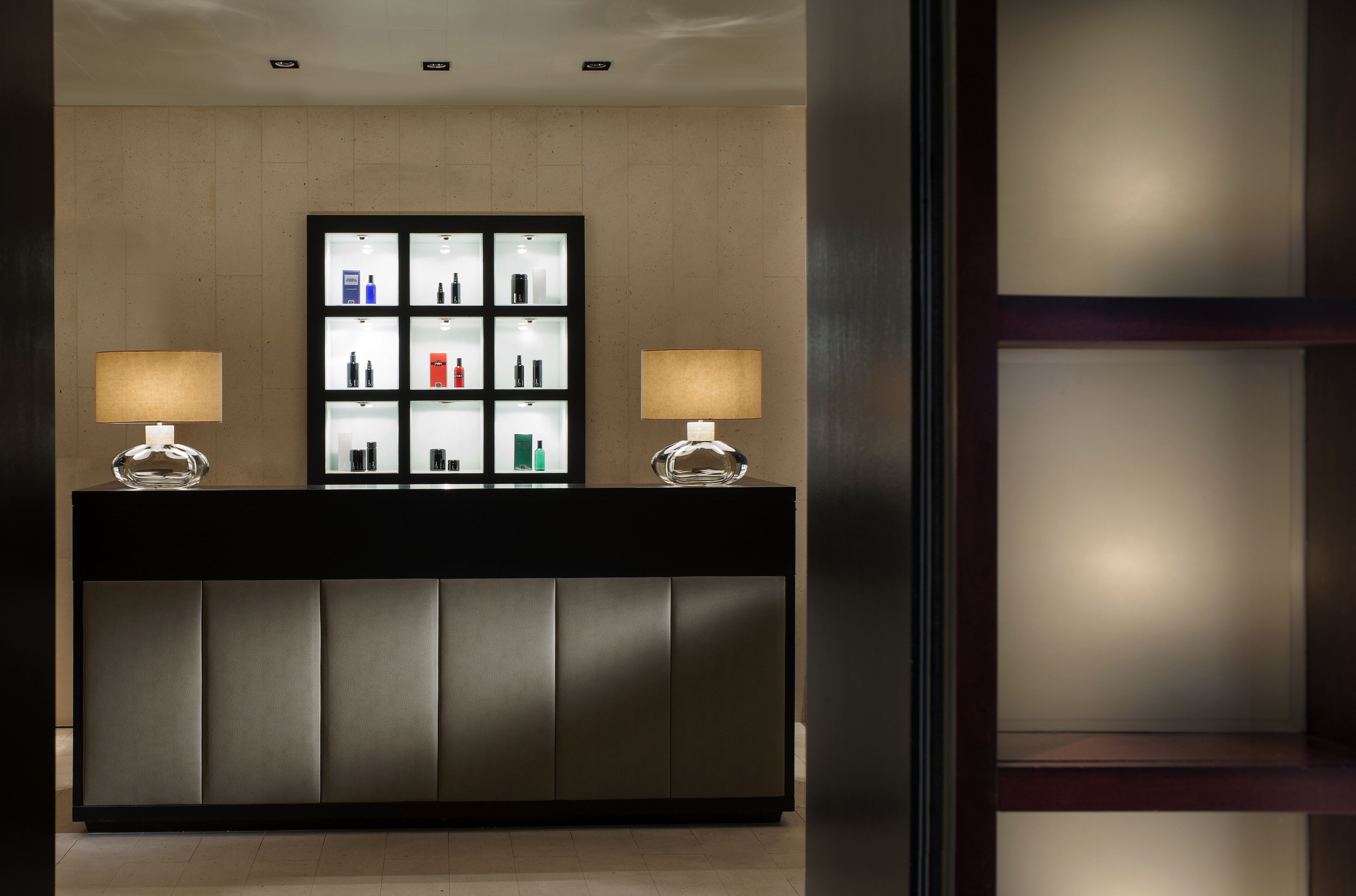 A reception desk with a modern design, featuring a black top and a glass display case with various items.