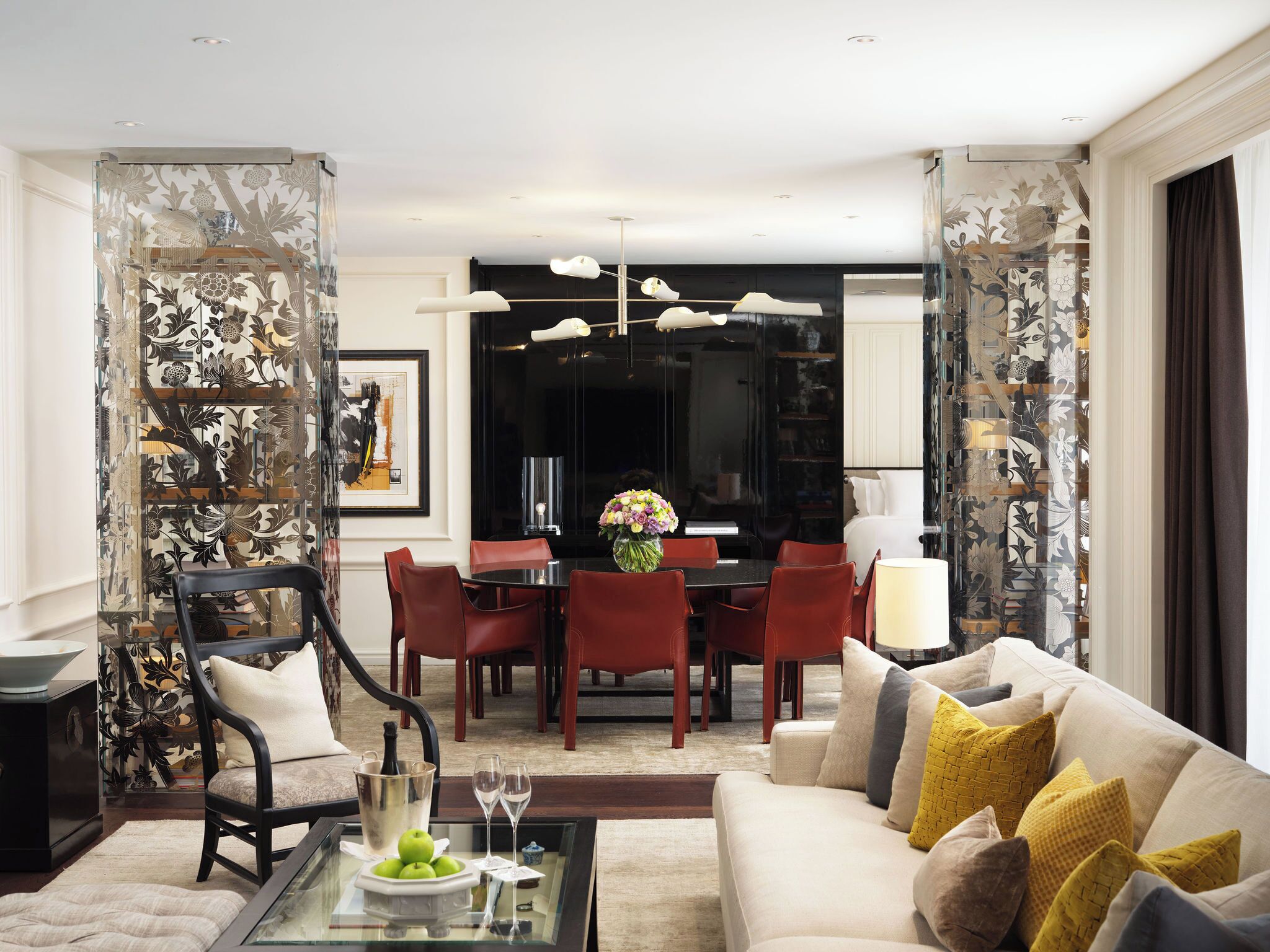 Un salon moderne comprenant un canapé, une table à manger avec des chaises et une table basse agrémentée d’objets décoratifs.