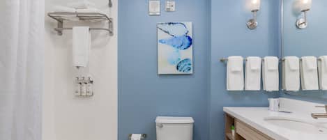 A modern bathroom with a bathtub, toilet, and sink.
