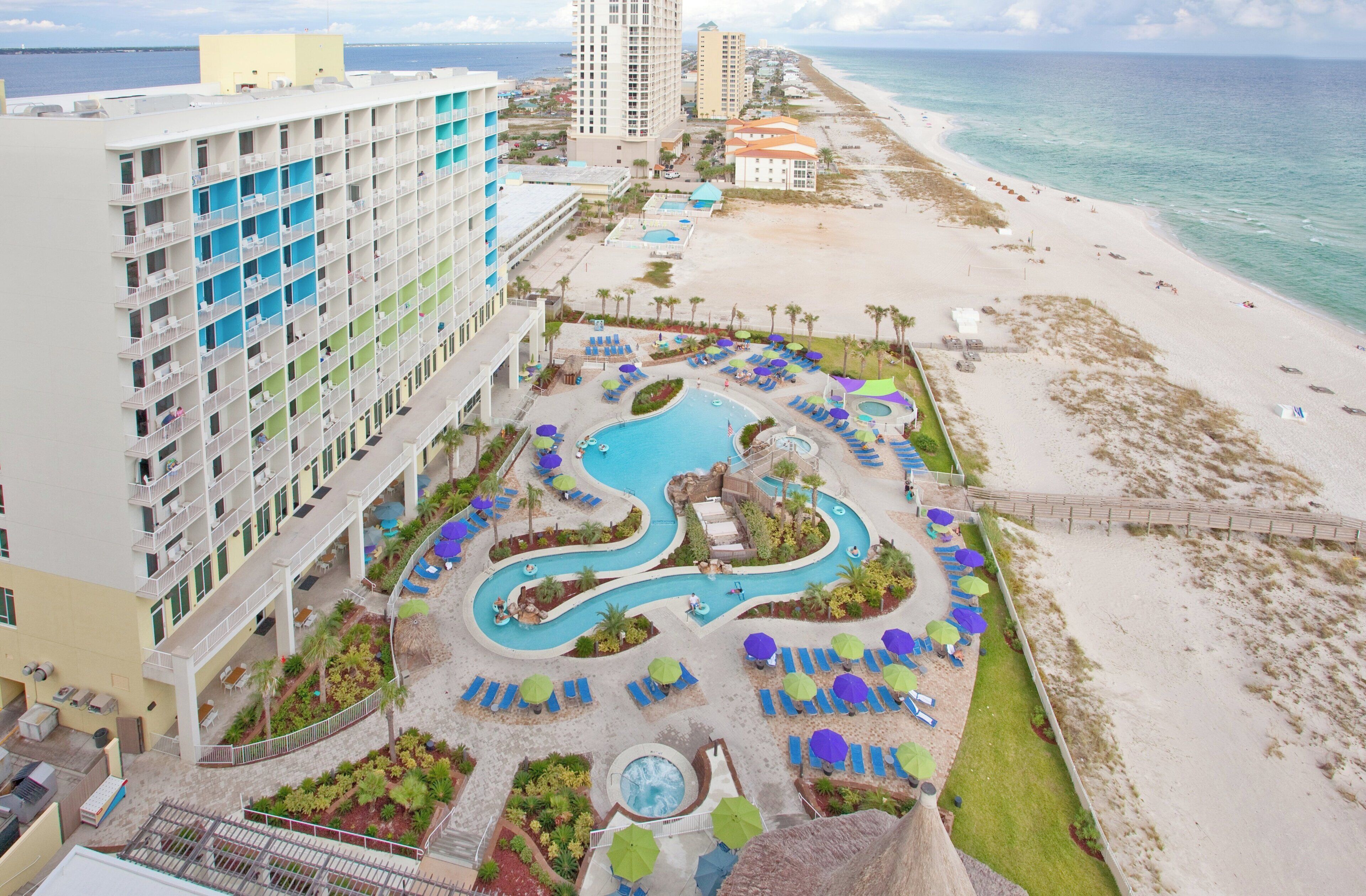 Ein Resort mit Poolbereich, Strand und Hotelgebäuden.