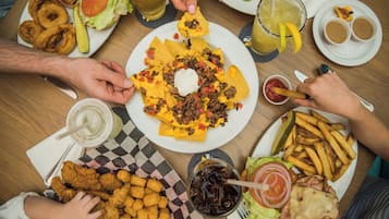 A table with various dishes including nachos, fries, and chicken nuggets.