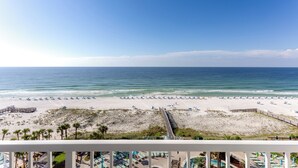 A beach view from a balcony with a wooden deck, beach umbrellas, and lounge chairs. - Holiday Inn Resort Pensacola Beach by IHG (Pensacola Beach)