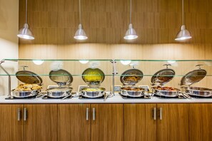 A buffet with various food items, including a bowl of soup, a container of fruit, and a dish with what appears to be meat. - Holiday Inn Resort Pensacola Beach by IHG (Pensacola Beach)