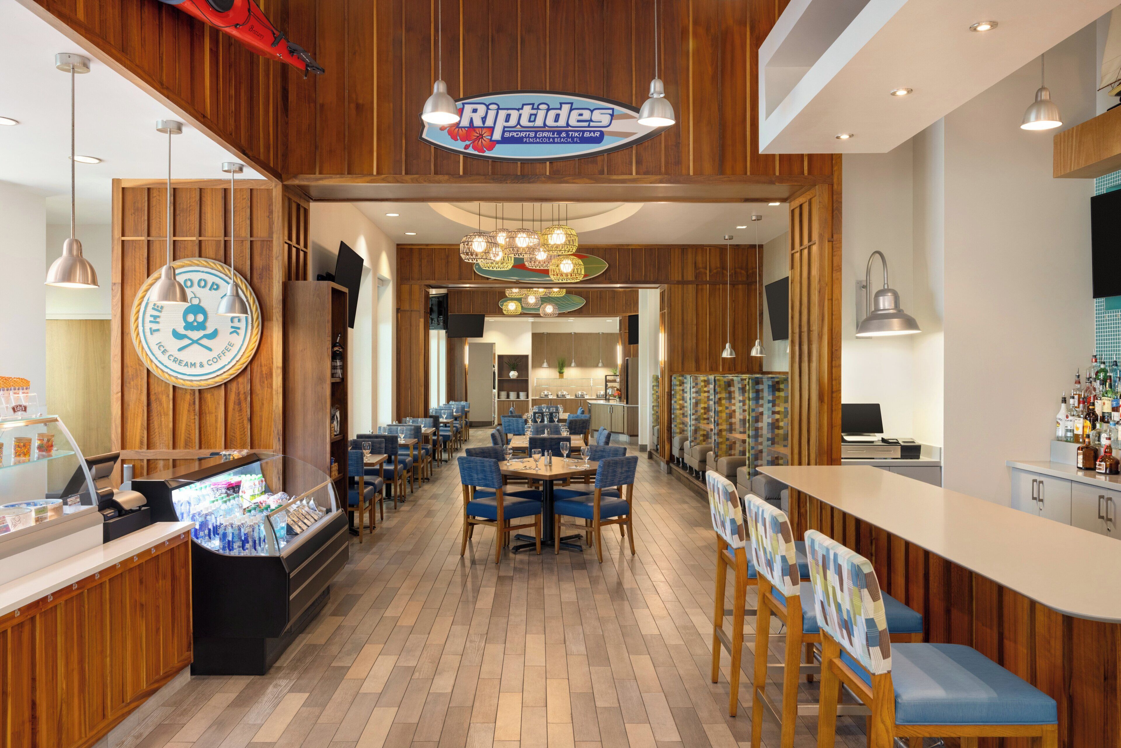 A restaurant interior with wooden paneling, a counter with a beverage display, and multiple seating areas.