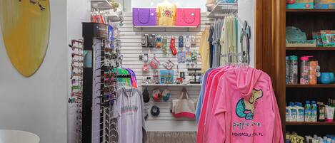 A retail store with various items on display including clothing, bags, and accessories.