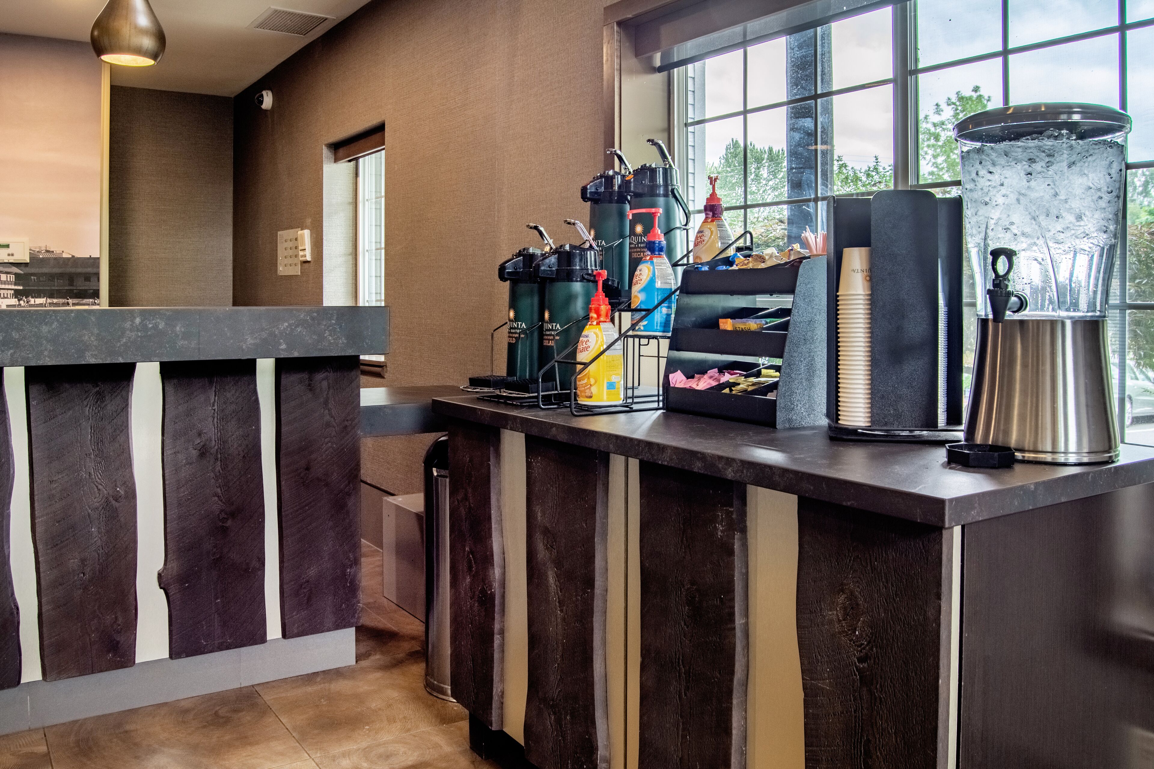 A bar area with a coffee machine, condiment dispensers, and a large water dispenser.