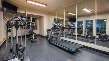 Un gimnasio con cintas de correr, elípticas y pesas sueltas.