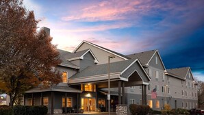 A multi-story hotel with a covered entrance, a flag, and a well-maintained driveway. - La Quinta Inn & Suites by Wyndham Eugene (Eugene)